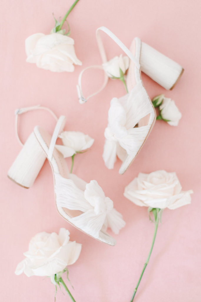White chunky heels with a bow on the front that would make the perfect wedding shoes for comfort and style