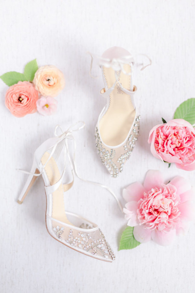 Transparent wedding heels with gem detailing on the front photographed with pink flowers