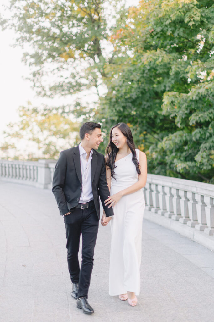 Beautiful engaged couple looks lovingly in one another's eyes as they take a stroll at Mount Royal in Montreal