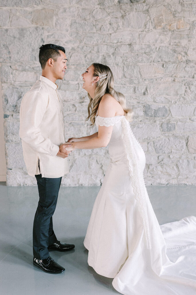 Bride flashes a smile at her husband while they face one another enjoying the moment during their first look wedding photos at Bonsecours Market in Montreal
