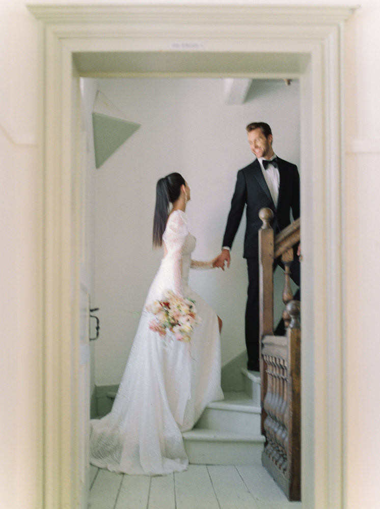 Groom leads his bride up the stairs at their Montreal wedding venue