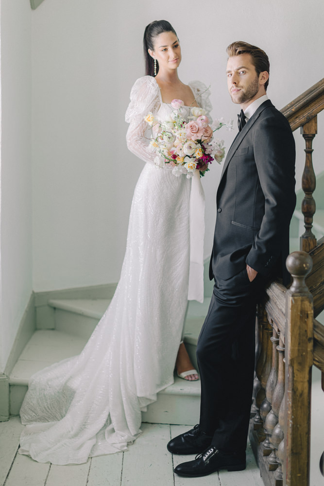 Modern bride and groom pose on the stairs at their Montreal wedding venue