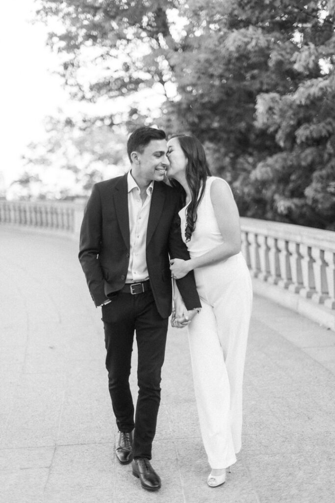 black and white photo of a couple strolling hand in hand during their engagement photoshoot