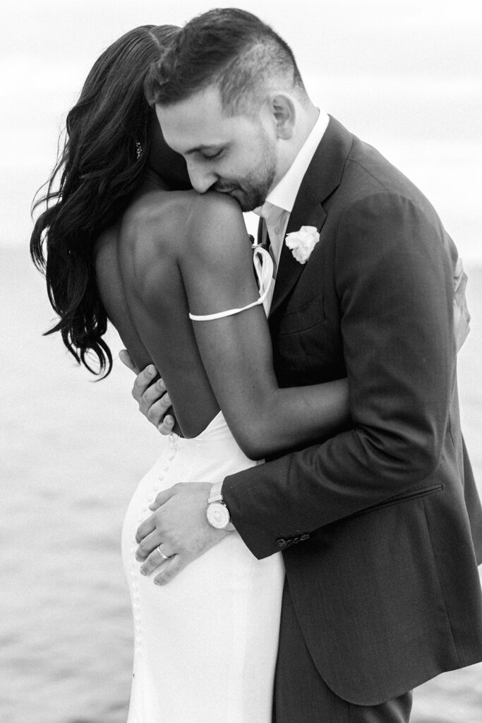 one of many black and white wedding images of gorgeous young newlyweds embracing on their big day