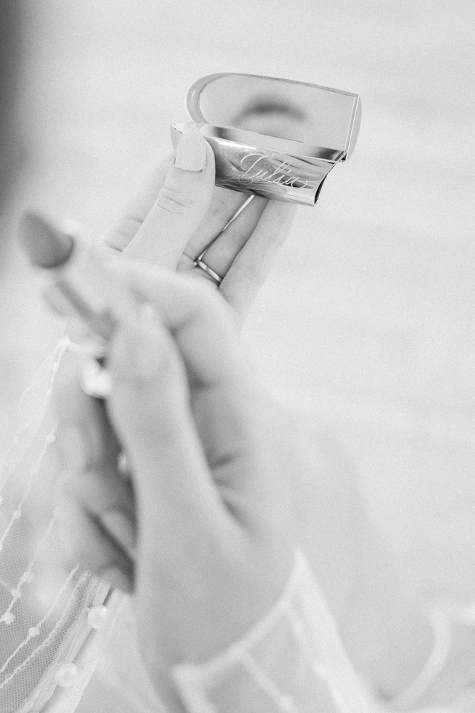 Black and white photo of a bride's lipstick mirror as she reapplies her shade