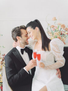 bride and groom cheers with champagne on their modern-styled wedding day
