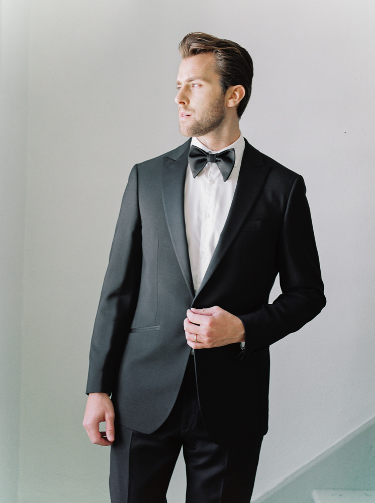 Groom gives modern wedding inspiration as he poses in his tux for a shot